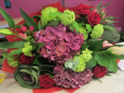 Romantic Opulence - A gorgeous mixture of Red Roses, lilies, cerise pinks,and vibrant green flowers give this bouquet a stunning look.